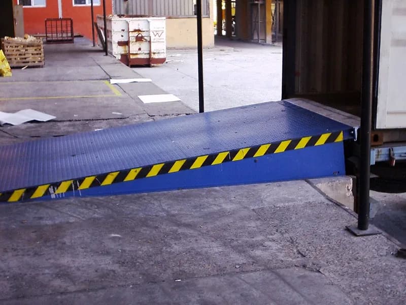 Dock leveler with hazard markings at a loading bay