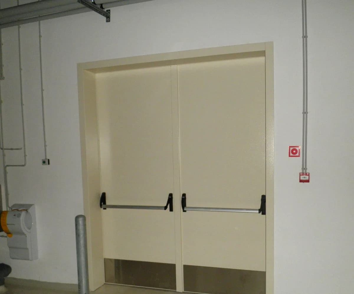 Double-leaf fire door with panic bars in a plant room